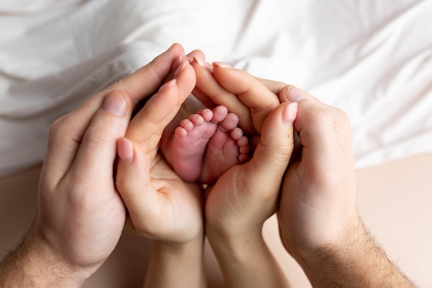 mani di genitori e figli. gambe di un neonato nelle mani di mamma e papà. le gambe del bambino nelle mani.