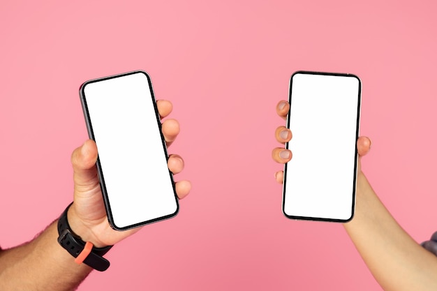 Mani di persone che tengono smartphone con schermo vuoto bianco