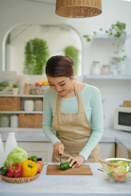 Mani di ragazze che tagliano le verdure sul tagliere