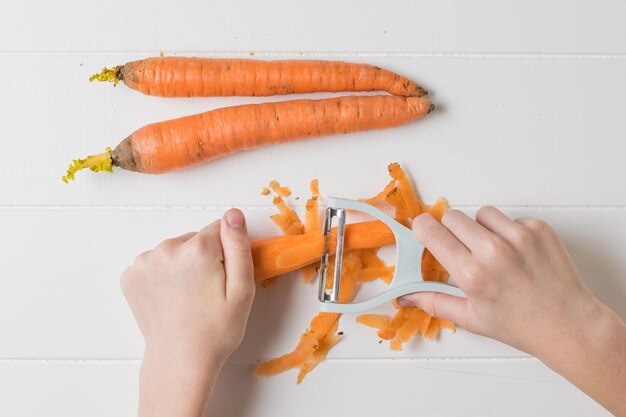 Mani di un bambino con un coltello speciale per sbucciare le verdure