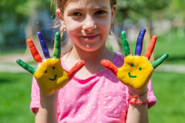 Mani di un bambino con un sorriso dipinto Messa a fuoco selettiva