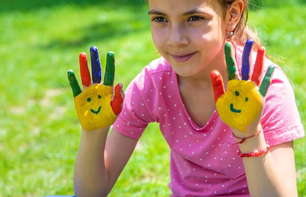 Mani di un bambino con un sorriso dipinto Messa a fuoco selettiva