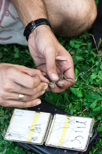 Mani di un giovane che fa attrezzi da pesca