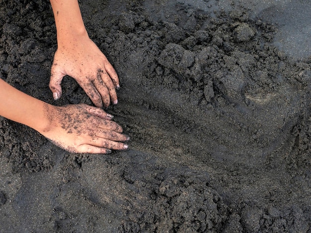 Mani di un ragazzo che gioca nella sabbia sulla spiaggia