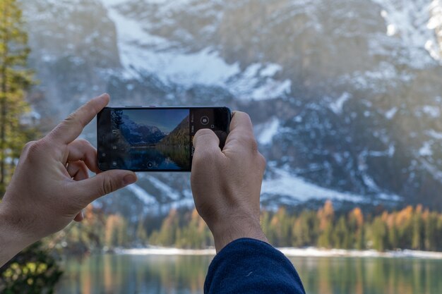 Mani di un uomo che scatta una foto in montagna