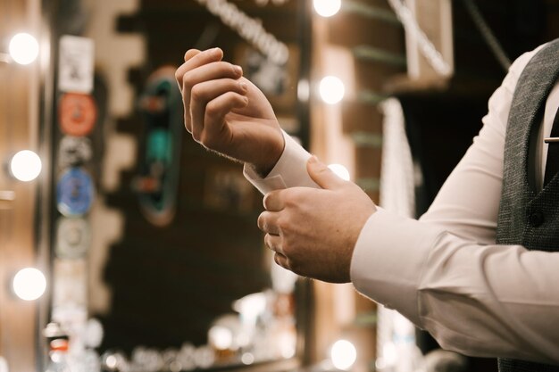 Mani di un uomo in giacca e cravatta in un interno elegante