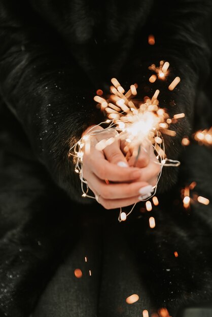 Mani di una ragazza con un primo piano sparkler