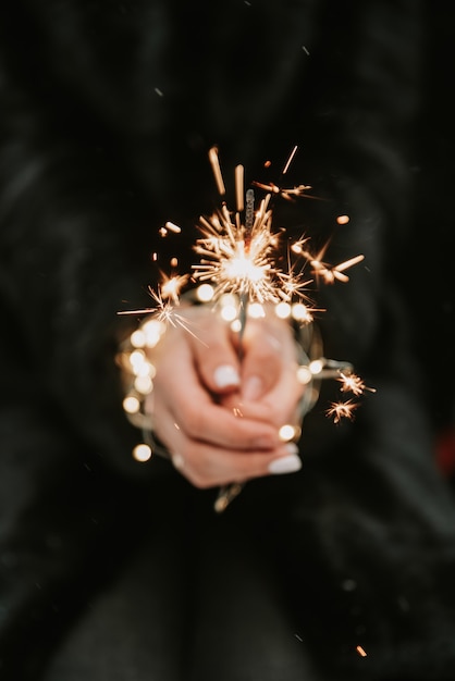 Mani di una ragazza con un primo piano sparkler