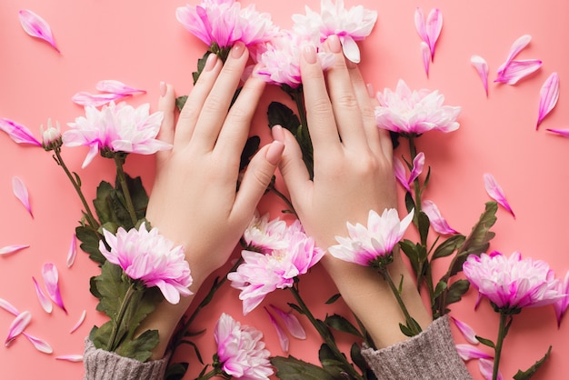 Mani di una ragazza con una manicure delicata in fiori