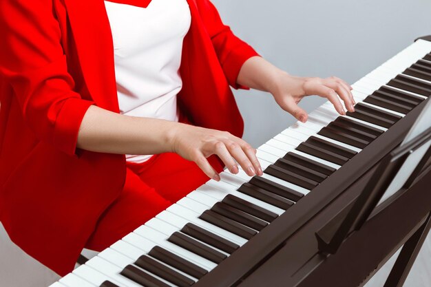 Mani di una ragazza pianista che suona il primo piano del pianoforte