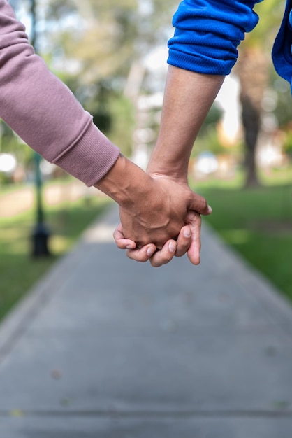 Mani di uomini che si tengono insieme in un parco