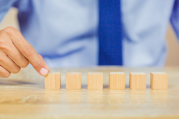 Mani di uomini d'affari, accatastando blocchi di legno.