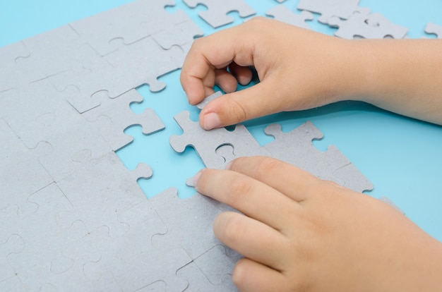 mani donne d'affari che collegano puzzle sul successo e la strategia del lavoro di squadra sul posto di lavoro