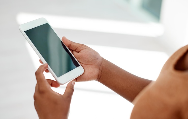 Foto mani e schermo della donna in ufficio con il cellulare per il social network sito web mobile e contatto digitale segretaria navigando sullo smartphone leggendo notifica aziendale e ricerca di media su mockup di app