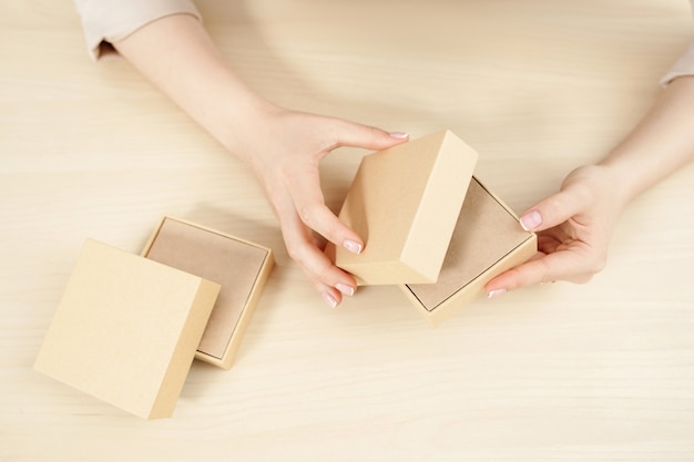 Mani femminili che aprono scatole di cartone
