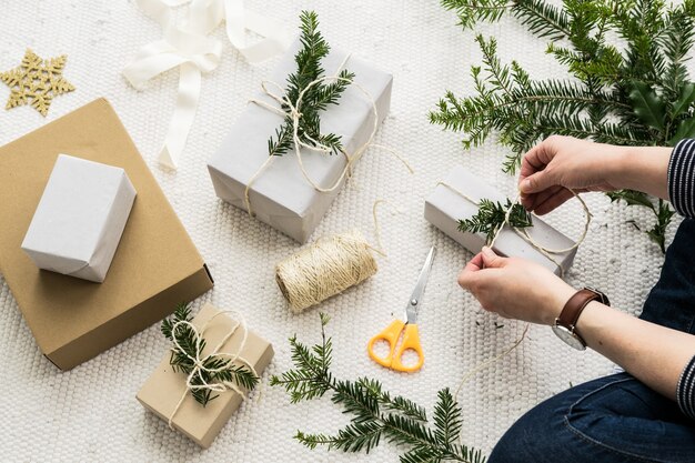 Mani femminili che avvolgono un regalo di Natale in carta d&#39;annata naturale