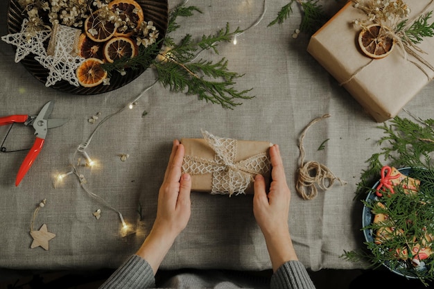 Mani femminili che decorano il regalo di Natale