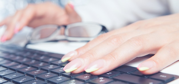 Mani femminili che digitano sul laptop