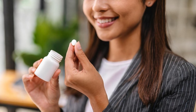 mani femminili che estraggono delicatamente una pillola da una bottiglia che riflettono le scelte di salute e benessere
