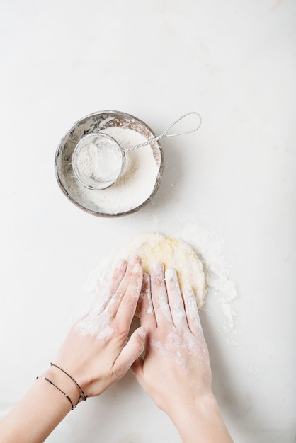 Mani femminili che impastano la pasta