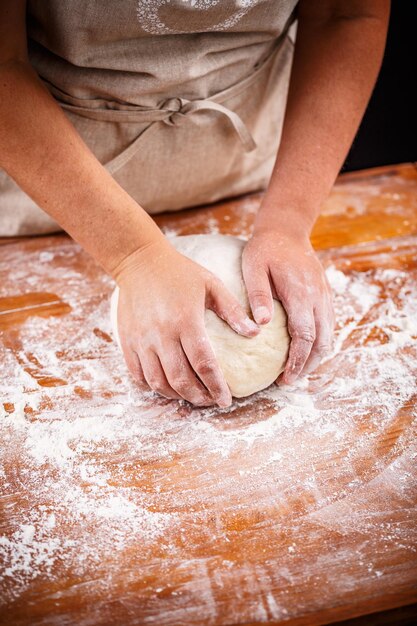 Mani femminili che producono pasta di pane