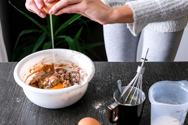 Mani femminili che producono pasta per la torta