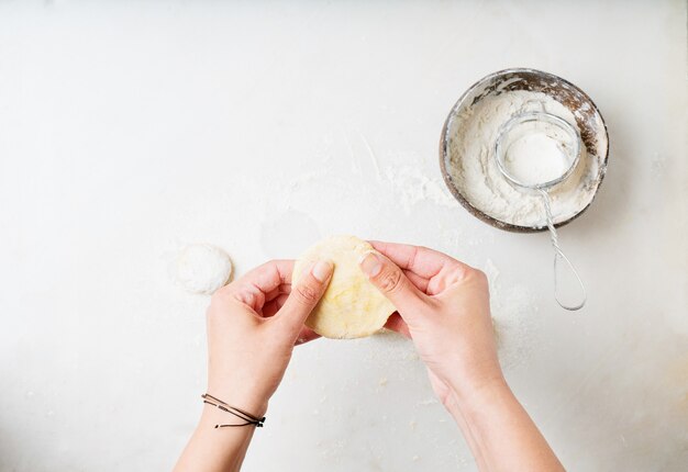 Mani femminili che rotolano le palle della pasta