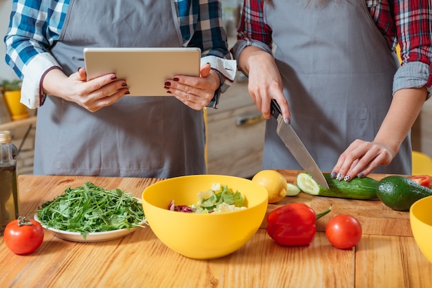 Mani femminili che tagliano le verdure in cucina