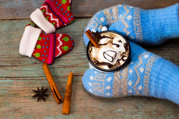 Mani femminili che tengono cioccolata calda con marshmallow.