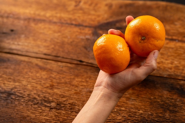 mani femminili che tengono le arance naturali