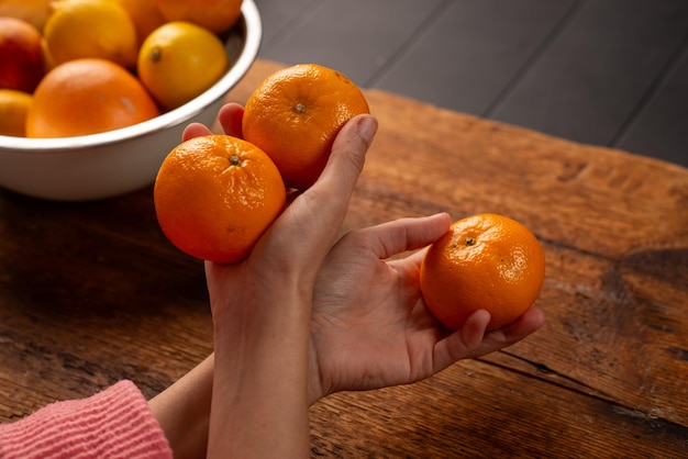 mani femminili che tengono le arance naturali