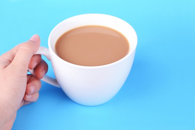 Mani femminili che tengono tazza di caffè bianco