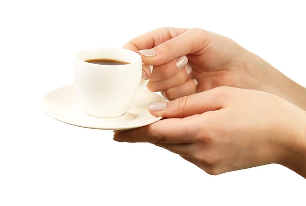 Mani femminili che tengono tazza di caffè con piattino isolato su bianco