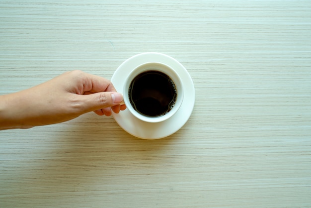 Mani femminili che tengono tazze di caffè