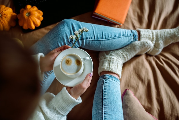 Mani femminili che tengono una tazza di tè o caffè caldo