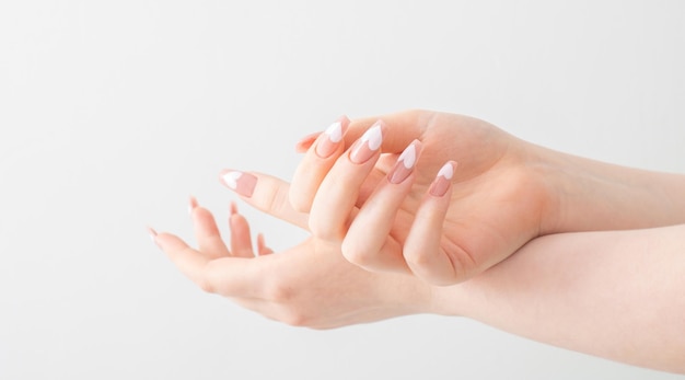 Mani femminili con belle unghie lunghe con manicure con motivo a cuore