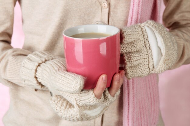 Mani femminili con bevanda calda, primo piano