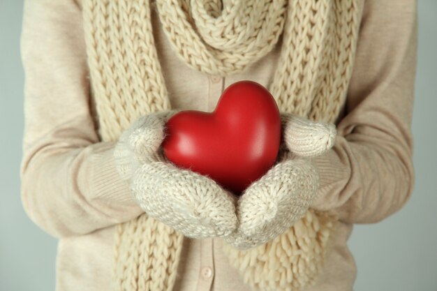 Mani femminili con cuore rosso, primo piano