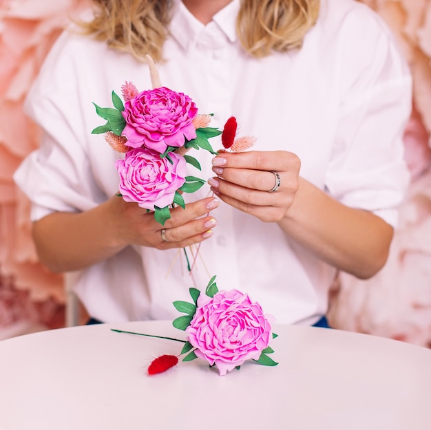 Mani femminili con peonie fatte a mano