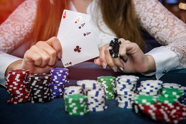 Mani femminili con quattro assi e fiches da poker