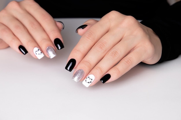 Mani femminili con unghie manicure nere, disegno cuori