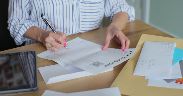 Mani femminili da vicino che mettono la lettera nel modulo di ritorno della busta Donna invia un modulo di restituzione per lettera