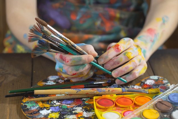 Mani femminili dell'artista con i pennelli