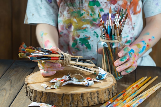 Mani femminili dell'artista con i pennelli