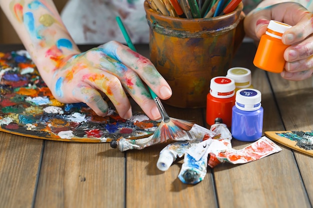 Mani femminili dell'artista con i pennelli