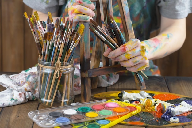 Mani femminili dell'artista con i pennelli