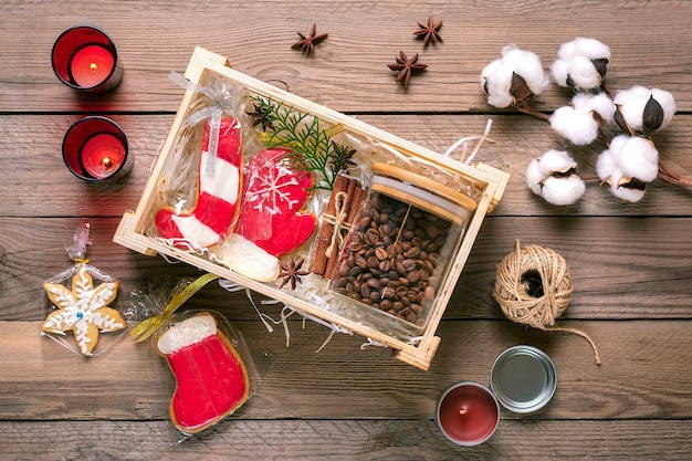 Mani femminili deposte pacchetto di cura, confezione regalo stagionale con caffè, pan di zenzero e cannella