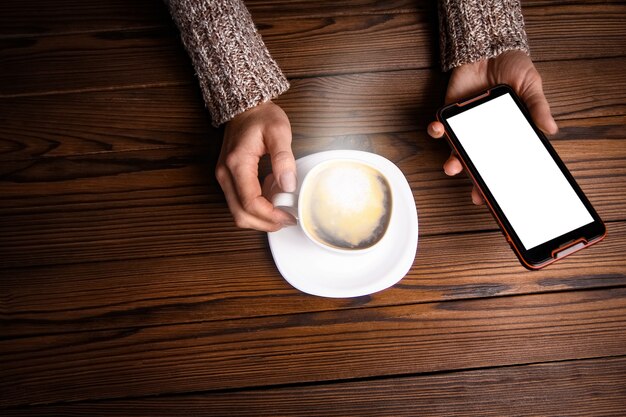 Mani femminili e caffè su fondo in legno