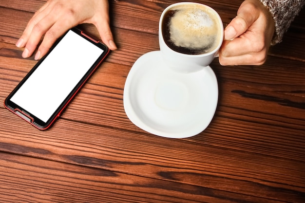 Mani femminili e caffè su fondo in legno