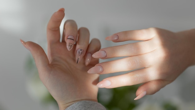 Mani femminili eleganti con unghie di mandorle beige close-up di manicure in gel glamour